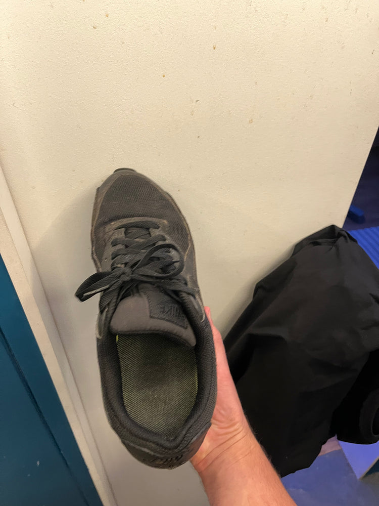 Holding all black sneaker with black inchmaxxer 2.0 height boosting insole invisible inside the shoe.